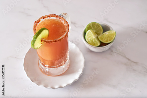 Michelada, Mexican alcoholic cocktail with beer, lime juice, tomato juice photo