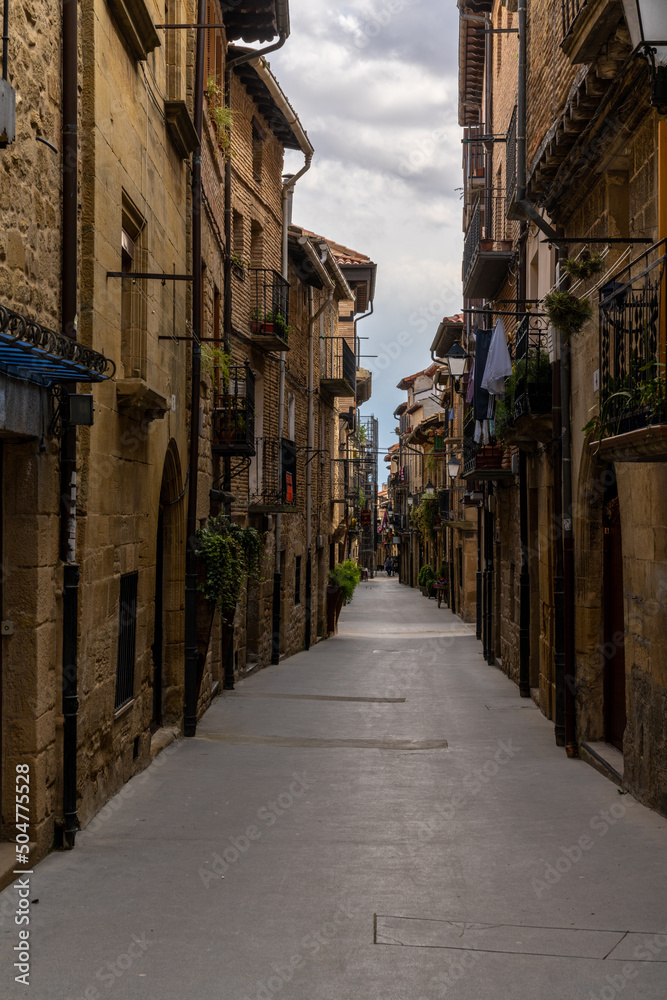 narrow picturesque street with brown stone buildings in the historic city center of Laguardia in La Rioja