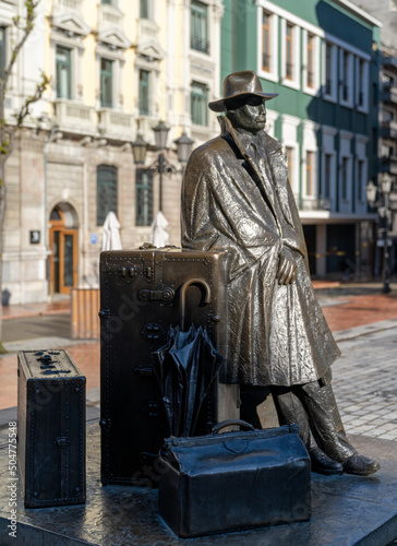 staute of man with suitcases in the historic city center of Oviedo photo