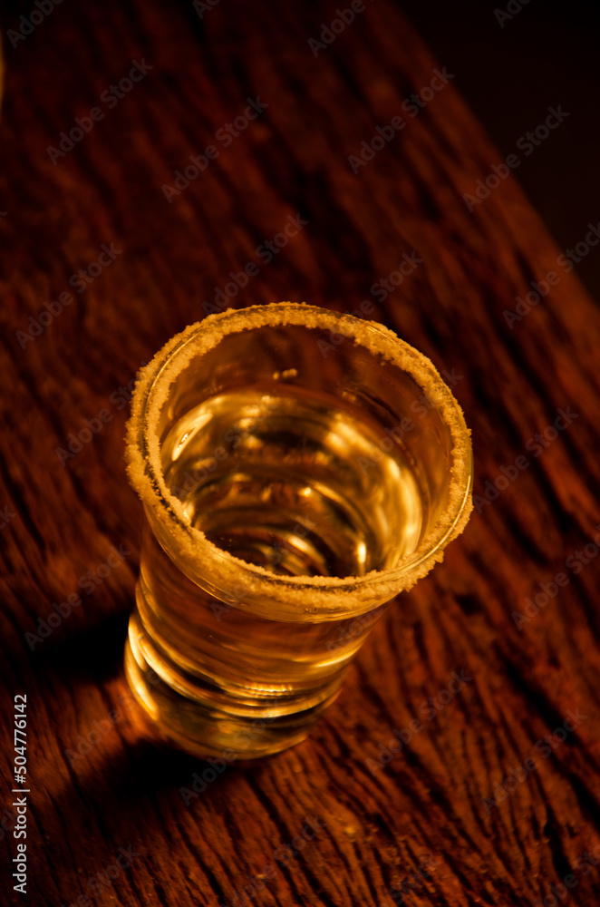 Glass of caipirinha, with the rim decorated with salt, accompanied by lemon and a wooden tray. Alcoholic beverage Glass of caipirinha, with the rim decorated with salt, accompanied by lemon and a wooden tray. Alcoholic beverage