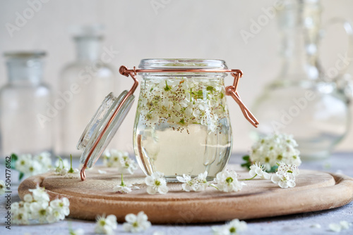 A jar filled with hawthorn flowers and alcohol - preparation of tincture photo