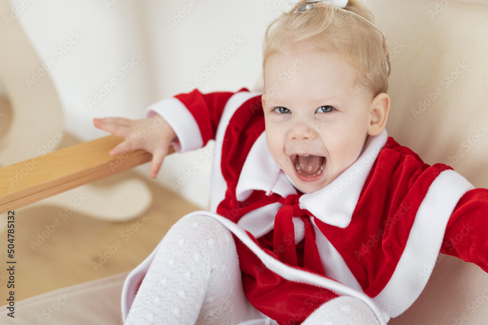 Child girl dressed in christmas dress with cochlear implants having fun at home - hearing aid and innovating technologies for treatment of deafness Child girl dressed in christmas dress with cochlear implants having fun at home - hearing aid and innovating technologies for treatment of deafness