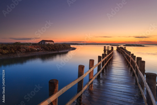 Amazing romantic view from the pier at sunset. Serene landscape on the lake at colorful sunset. Old wooden pier in a fineart photo © aroxopt