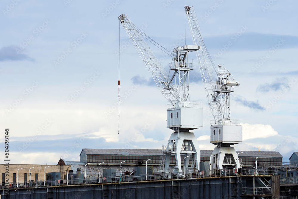 Construction cranes on top of a floating dock, shipbuilding, shipyard crane