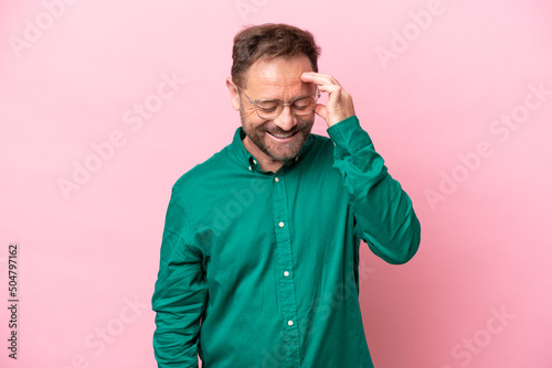 Middle age caucasian man isolated on pink background laughing © luismolinero