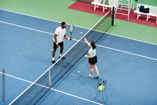 High angle shot of African American man playing tennis at practice with partner or coach, copy space © Seventyfour