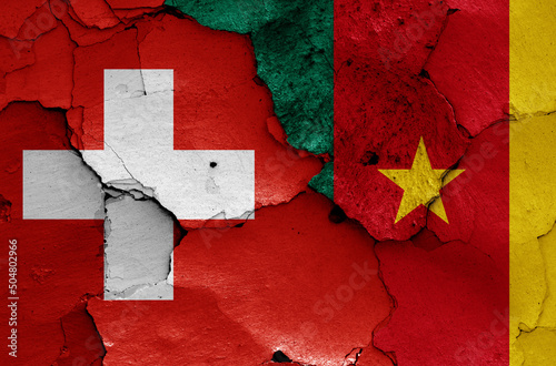 flags of Switzerland and Cameroon painted on cracked wall photo