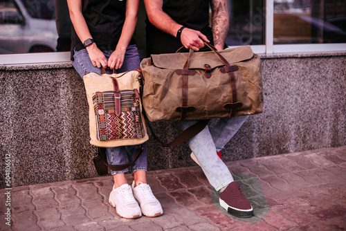 Woman and man holding canvas bags. Backpack and duffel canvas bag photo