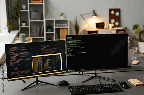 Background image of two computers at workplace with code lines on screen in IT developers office, copy space