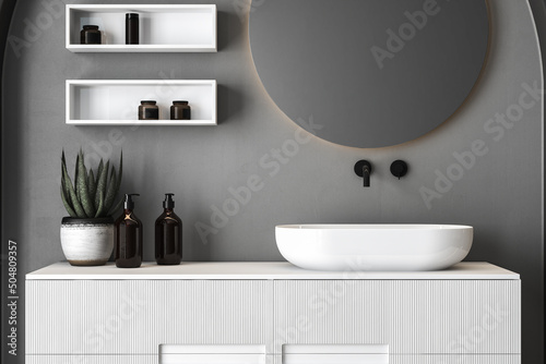 Close up of sink with oval mirror standing in on concrete wall, white cabinet with black faucet in minimalist bathroom. Mock up, stand, front view. 3d rendering © leymandesign