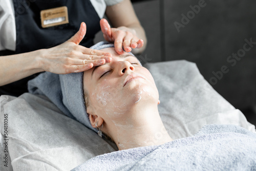 Young beautiful woman doing beauty treatment, massage in the salon. photo