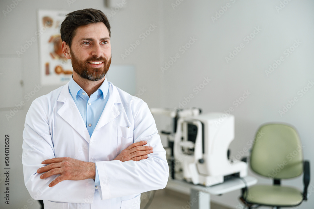 Smiling ophthalmologist on the background of professional ophthalmic equipment Smiling ophthalmologist on the background of professional ophthalmic equipment