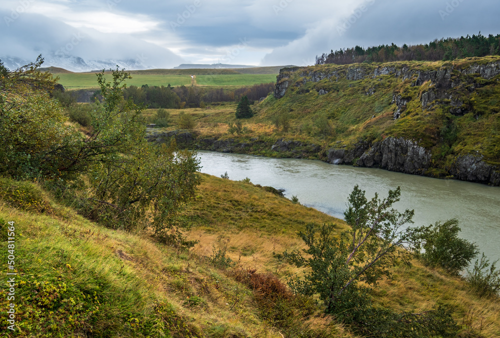 Obraz premium Hrutey island public park near Blonduos town, North-West of Iceland. View during auto trip by Ring Road. Spectacular Icelandic landscape with scenic autumn nature and Blanda river with cataracts.