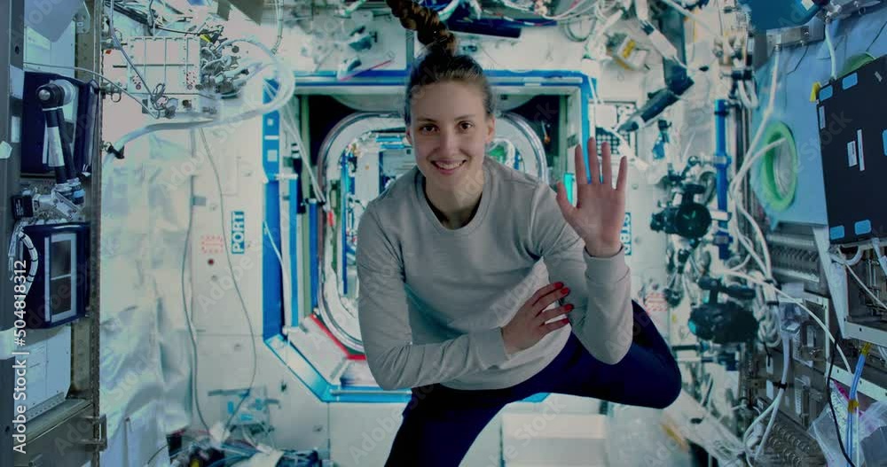 Female astronaut waving to camera inside the International space station. ISS. Some elements of the video furnished by NASA