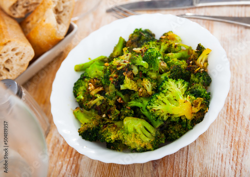 Plate of freshly roasted green broccoli for healthy vegetarian lunch. Diet food