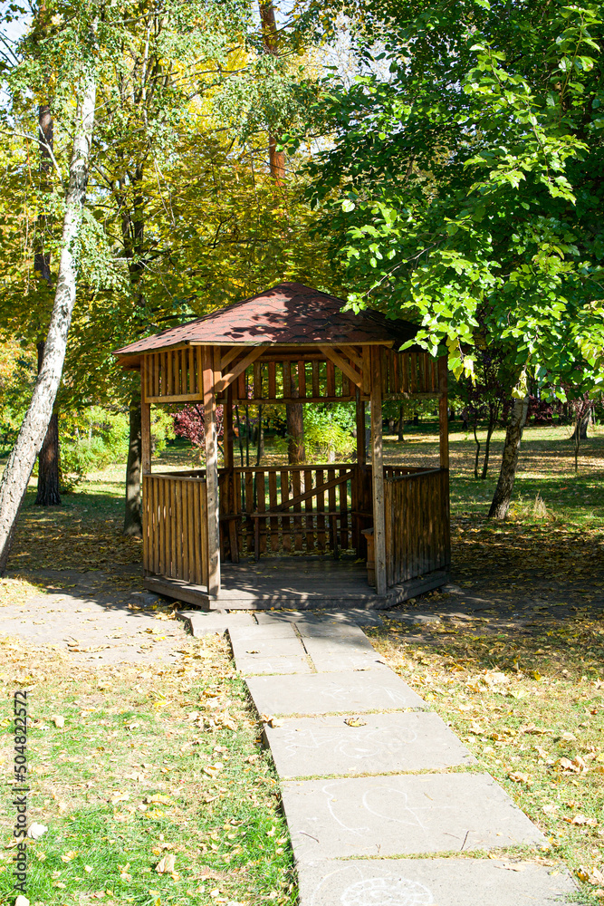 Wooden gazebo in the forest or park under the sun Wooden gazebo in the forest or park under the sun