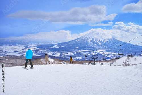 春スキーのニセコスキー場、今から滑るコースを眺める滑走前のスキーヤーとスノーボーダー達