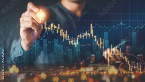 Businessman writing analyze graph for trade stock market on the screen. Businessman hand drawing chart graph stock of growth. Hand man uses pen to draw stock graph chart point of target success.