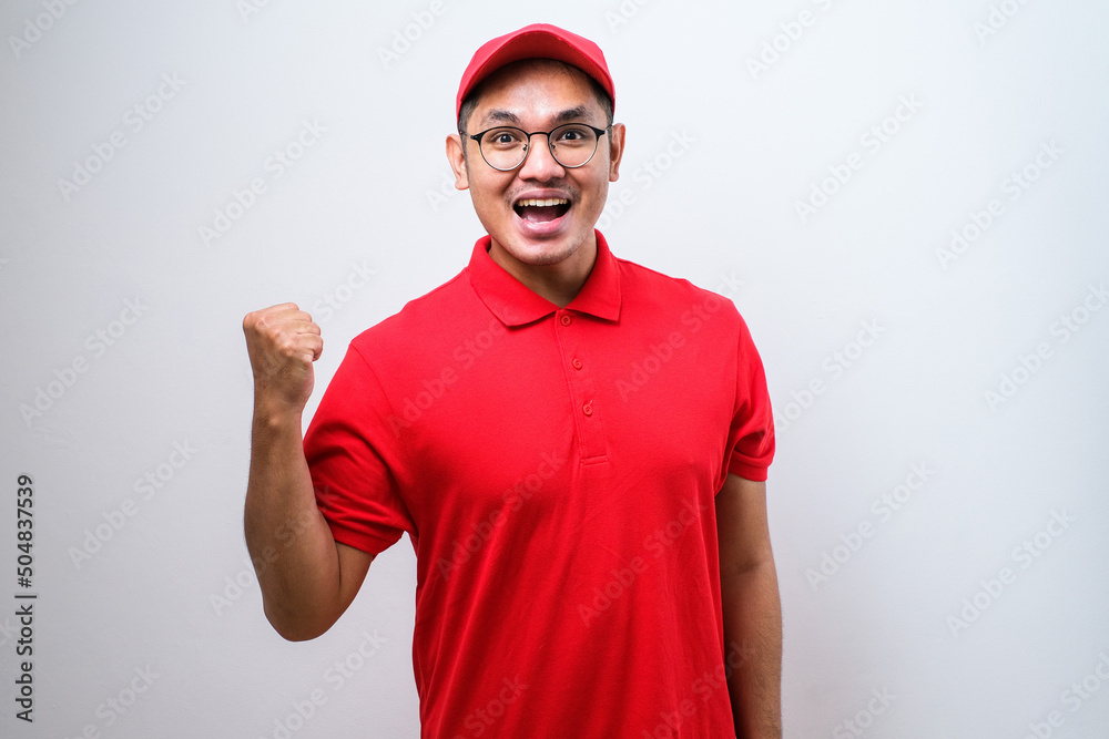 Asian delivery man doing winner gesture with arms raised, smiling and screaming for success. Celebration concept. Asian delivery man doing winner gesture with arms raised, smiling and screaming for success. Celebration concept.