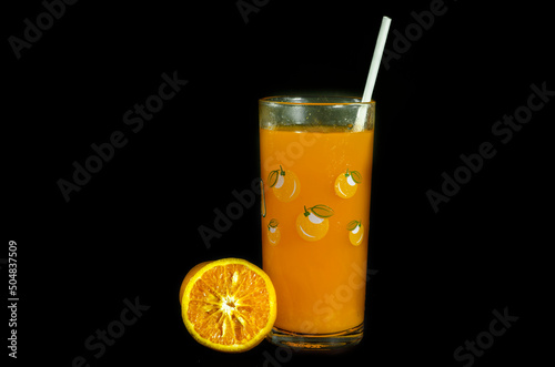 glass of orange juice with cut orange isolate on black background photo