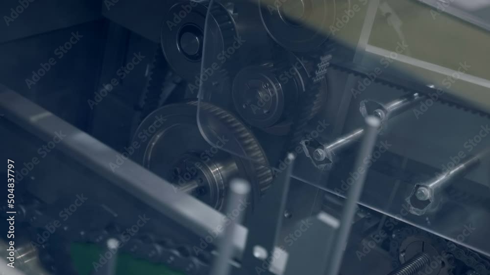 Movable elements, metal gears, drive belts, chains and conveyor elements in the operation of industrial equipment operate cyclically in automatic mode all the time. Closeup Movable elements, metal gears, drive belts, chains and conveyor elements in the operation of industrial equipment operate cyclically in automatic mode all the time. Closeup