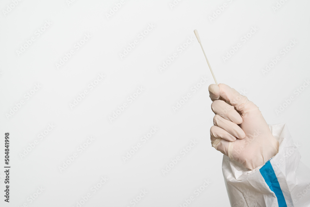 Female doctor or nurse wearing protective suit is holding a cotton swab