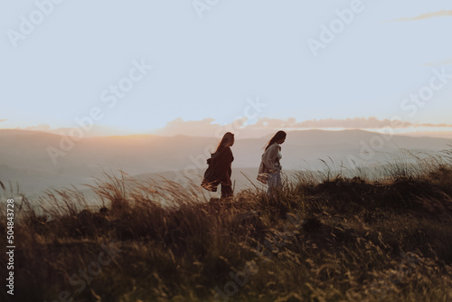 Dos mujeres caminando por la colina en un atardecer en Sudamérica. Concepto de viajes y paisajes.