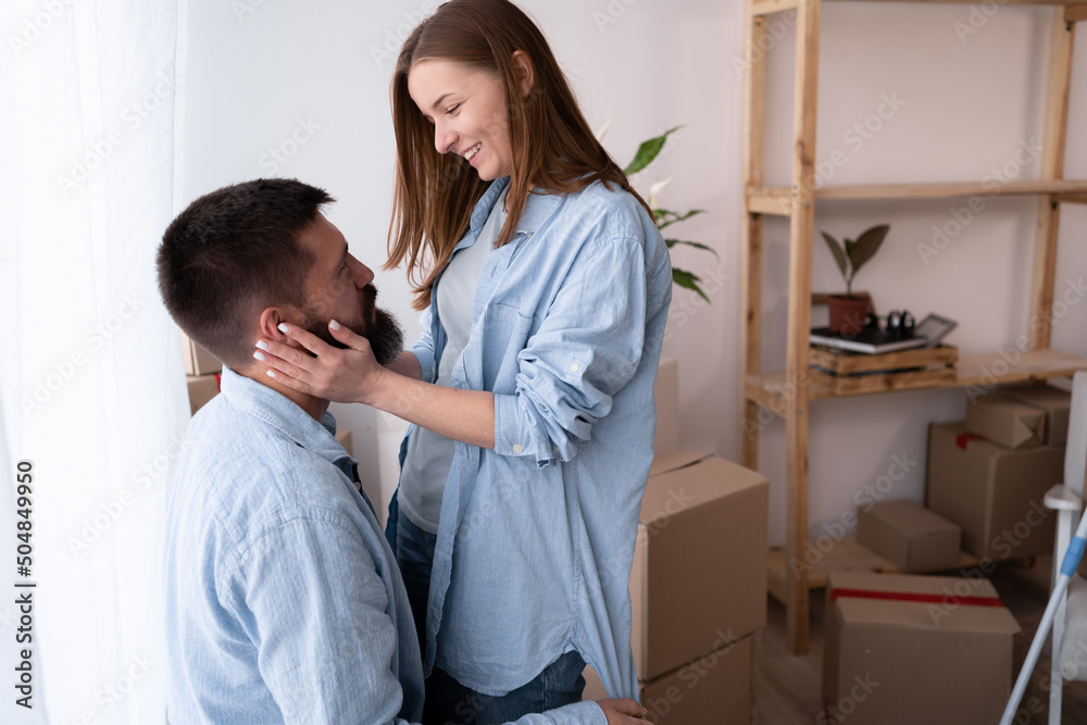 Young couple in new apartment embracing man and woman after buying property. guy and girl owners of a new house. moving and relocation concept