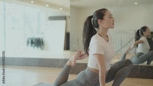 ヨガポーズをする講師の女性