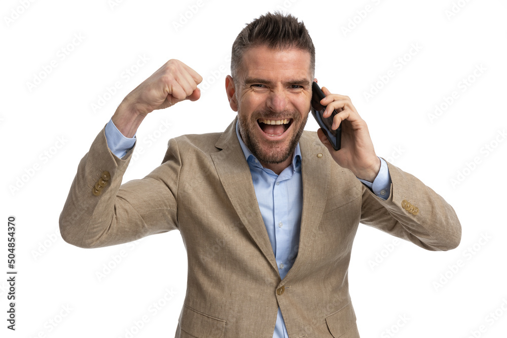 excited businessman talking on the phone and celebrating victory excited businessman talking on the phone and celebrating victory