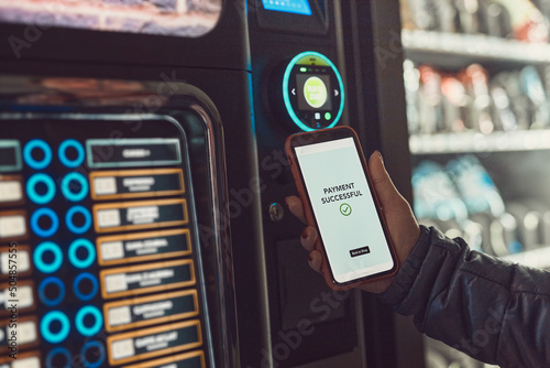 Foto Consumer paying for product at vending machine using contactless method of payment with mobile phone