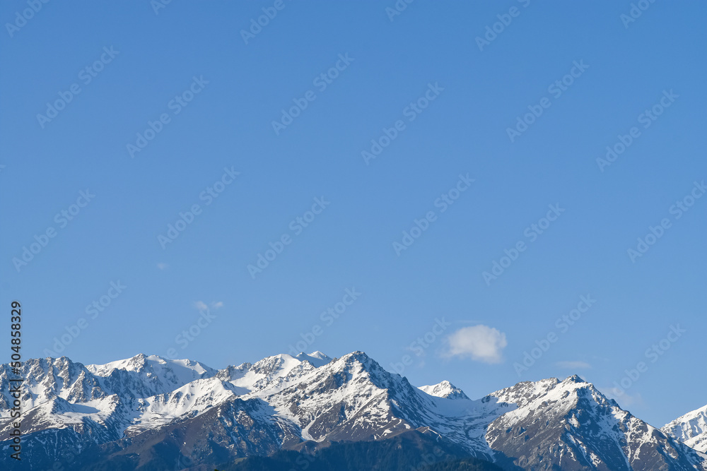 Shot of snow-capped and covered with green forests mountains (summer, spring). Kazakhstan, Qazaqstan, Almaty