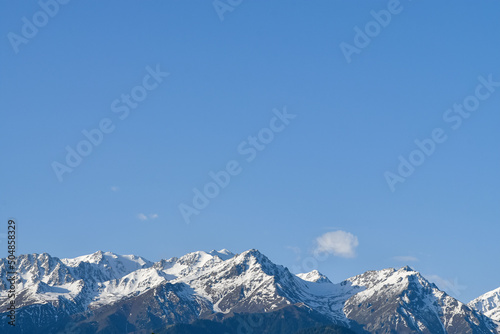 Shot of snow-capped and covered with green forests mountains (summer, spring). Kazakhstan, Qazaqstan, Almaty