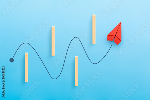 Business for solution and overcoming barriers concept with red paper plane, blue background photo