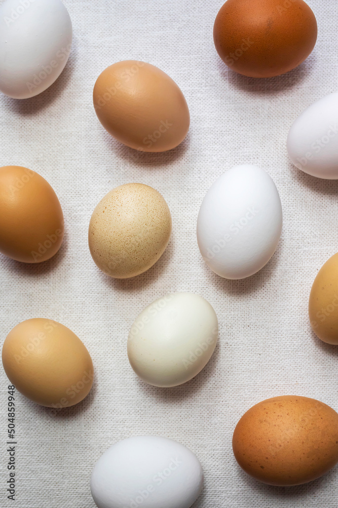 Fresh raw natural chicken eggs on white canvas. Top view. Fresh raw natural chicken eggs on white canvas. Top view.