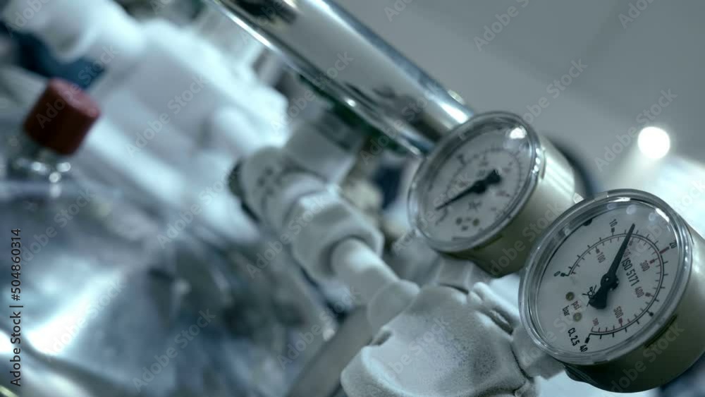 The arrow of the pressure gauge of compressed gas fluctuates due to the flow of this gas, and the pipelines are covered with frost due to a large temperature difference. Closeup The arrow of the pressure gauge of compressed gas fluctuates due to the flow of this gas, and the pipelines are covered with frost due to a large temperature difference. Closeup