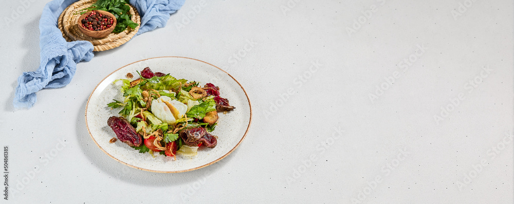 Green salad with sliced roast beef and pachot egg. Roast beef salad with vegetables and egg on concrete background in minimal style. Aesthetic composition with meat salad, textile and spices. Green salad with sliced roast beef and pachot egg. Roast beef salad with vegetables and egg on concrete background in minimal style. Aesthetic composition with meat salad, textile and spices.