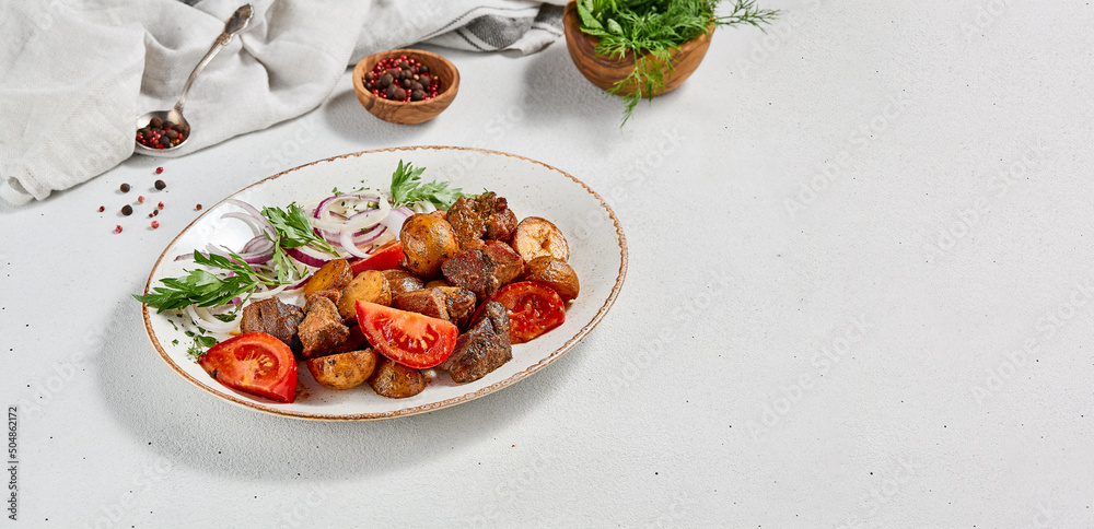 Traditional georgian dish odjahuri with meat and potatoes. Roasted pork fillet and potatoes with onion and tomatoes. Stew meat and potatoes. Eastern food with pork and spices Traditional georgian dish odjahuri with meat and potatoes. Roasted pork fillet and potatoes with onion and tomatoes. Stew meat and potatoes. Eastern food with pork and spices