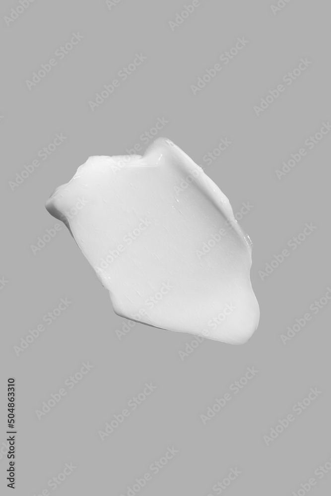 A smear of cosmetic cream , smudges on a Gray background. A smear of cosmetic cream , smudges on a Gray background.
