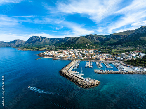 Spain, Balearic Islands, Colonia de Sant Pere, Helicopter view of coastal town in summerwith mountains in background