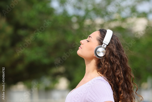 Woman listening audiobook meditating in a park photo