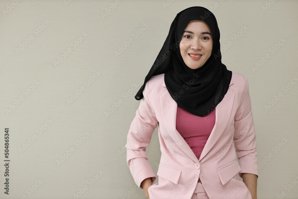 Happy and smart asian business woman in muslim dress standing and holding hands pockets with confident. Isolated background portrait with smiling beauty face in hijab. Advertisement portrait concept Happy and smart asian business woman in muslim dress standing and holding hands pockets with confident. Isolated background portrait with smiling beauty face in hijab. Advertisement portrait concept