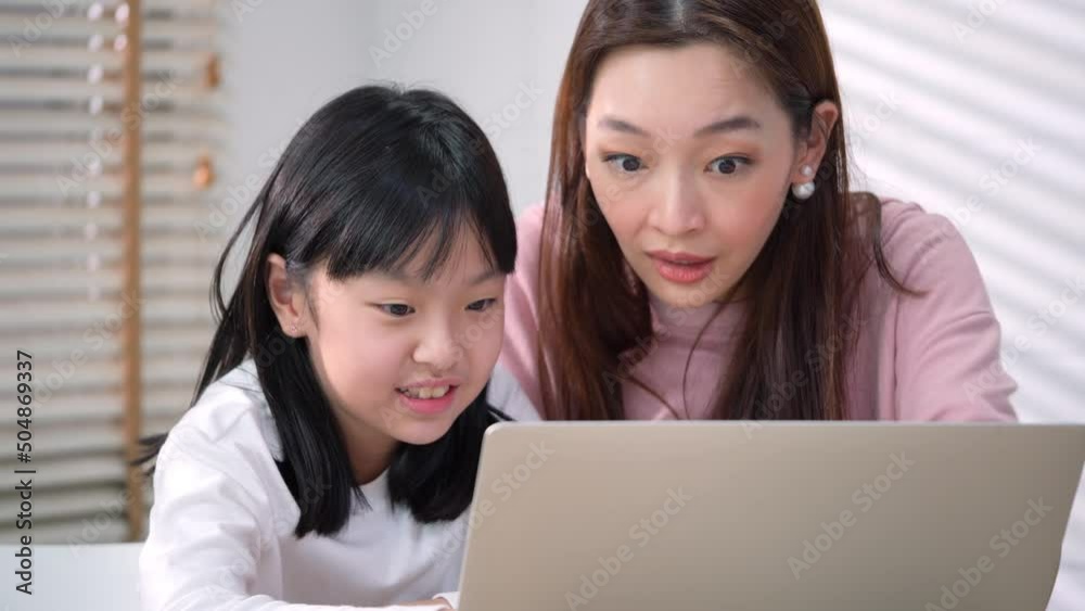 Happy family enjoyment expression with conference online at home. Mother and daughter using internet on laptop. Happy family enjoyment expression with conference online at home. Mother and daughter using internet on laptop.