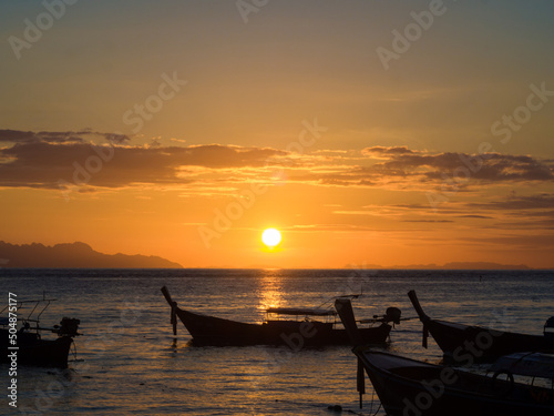 Silhouette sunset light on sea beach with wooden boat colorful sky cloud