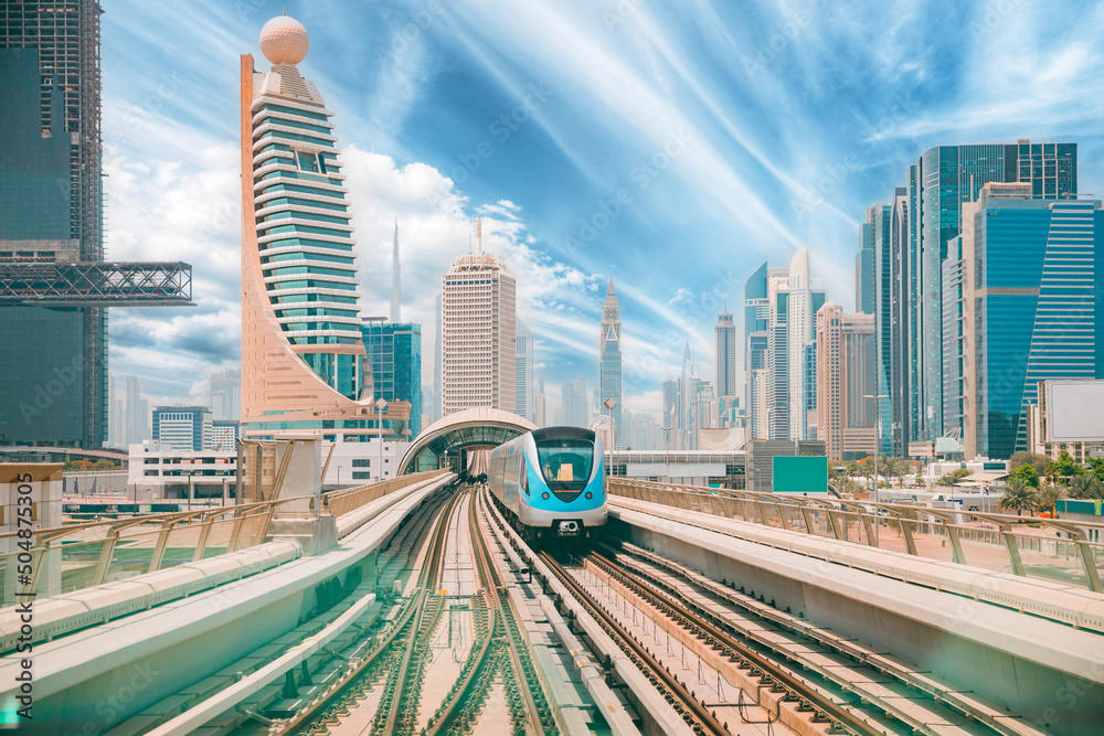 Monorail Subway train rides among glass skyscrapers in Dubai. Traffic on street in Dubai. Cityscape skyline. Urban background. Altered sky.
