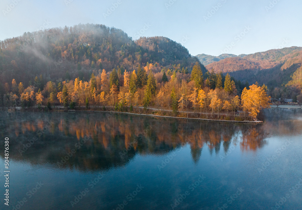 Lake Bled on a foggy and misty autumn morning. Vivid sunrise on a beautiful autumn day.