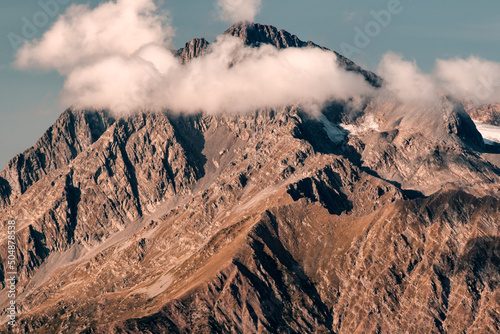 Mountain peak on a background of blue sky with clouds