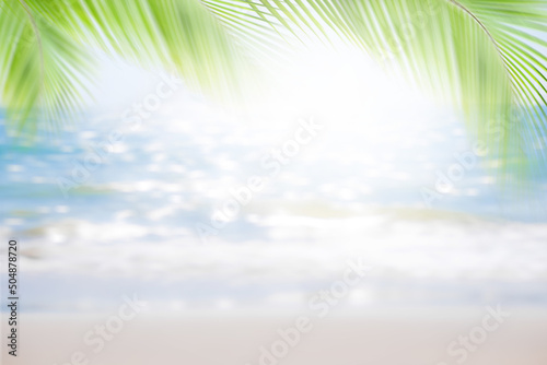 Blur Sand beach with palm leaves blue sea and blue sky white cloud beautiful at coast. bokeh blue ocean shore outdoor nature landscape water background. tourist summer travel holidays tropical season