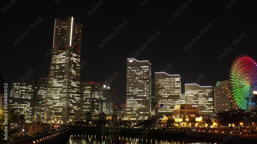 SAKURAGICHO, YOKOHAMA, JAPAN : View of cityscape of “Minatomirai“ area at night. Urban downtown area in central Yokohama city. View of buildings around the harbor or port or bay. Time lapse shot. SAKURAGICHO, YOKOHAMA, JAPAN : View of cityscape of “Minatomirai“ area at night. Urban downtown area in central Yokohama city. View of buildings around the harbor or port or bay. Time lapse shot.