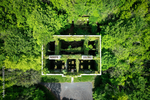 A big ruin house covered ivy and surrounded by a forest , Moore Hall is located in county Mayo Ireland and is now a public area